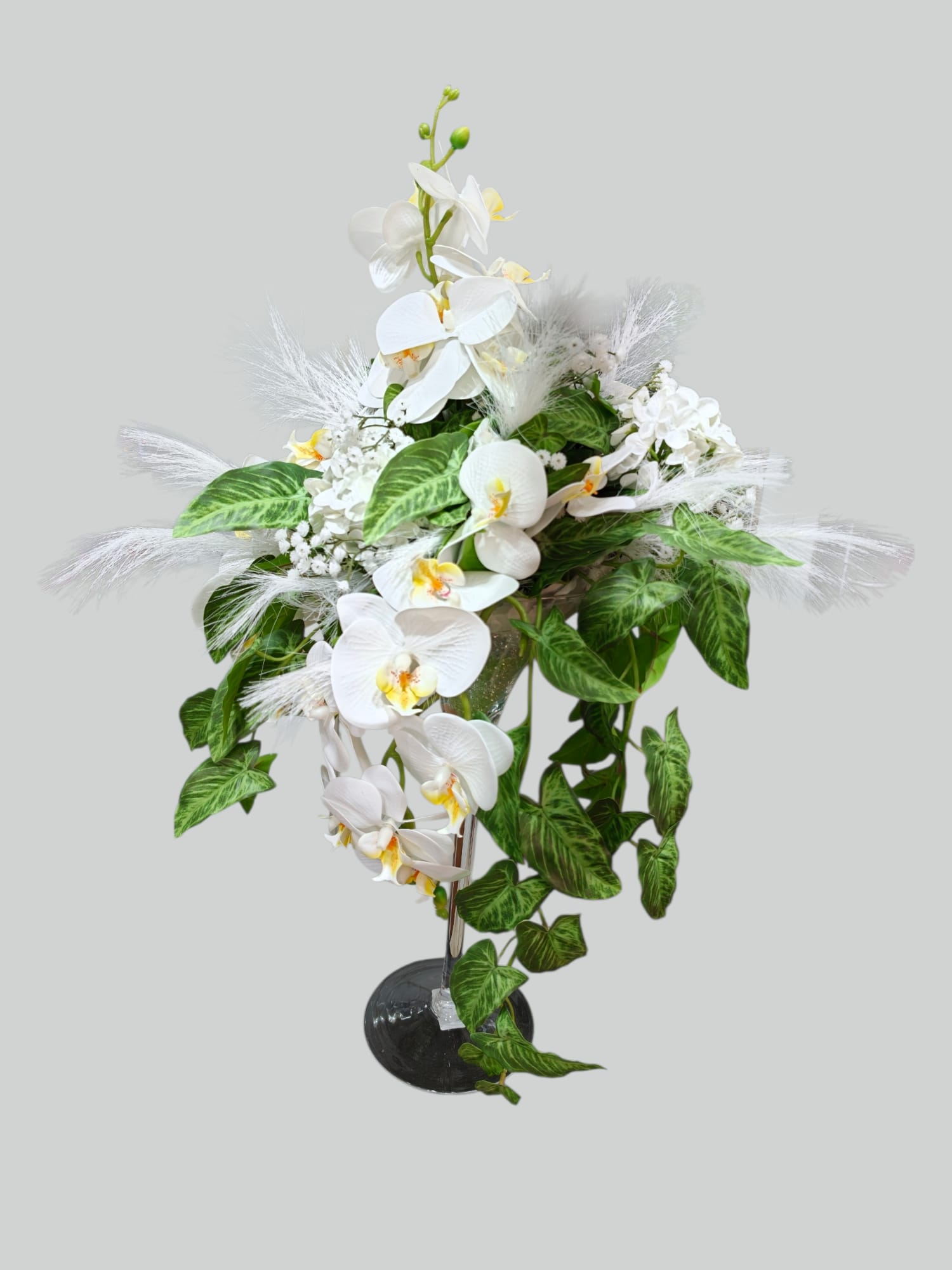 Cascata di Phalaenopsis artificiali bianche con foglie verdi variegate e dettagli floreali chiari